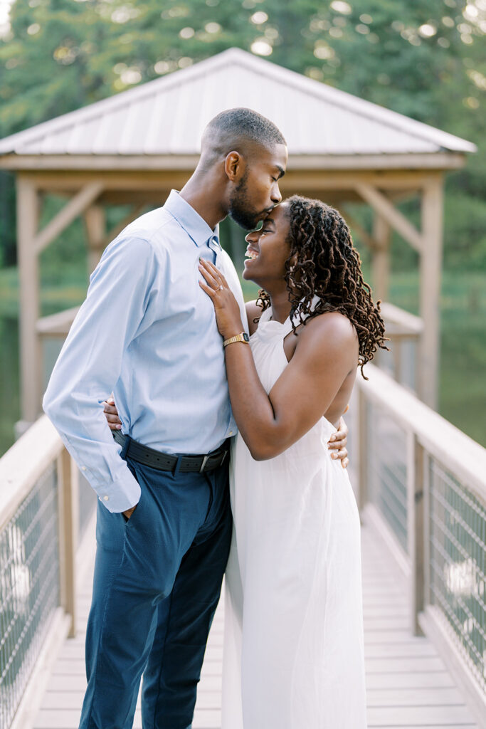Agnes and Uzo share a tender forehead kiss inside the gazebo at Union Grove Barn in Chapel Hill, North Carolina, during their romantic engagement session, captured by North Carolina wedding photographer Jessica Leigh Mason.