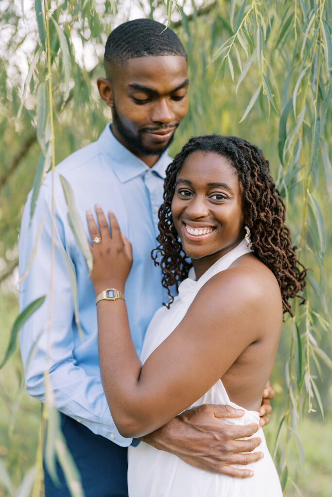 Agnes and Uzo embrace beneath the sweeping branches of a weeping willow at Union Grove Barn in Chapel Hill, North Carolina, captured by North Carolina wedding photographer Jessica Leigh Mason.

