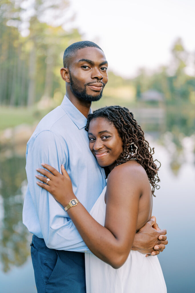 Agnes and Uzo share a sweet embrace while both smiling at the camera during their engagement session at Union Grove Barn in Chapel Hill, North Carolina, captured by Durham wedding photographer  Jessica Leigh Mason.