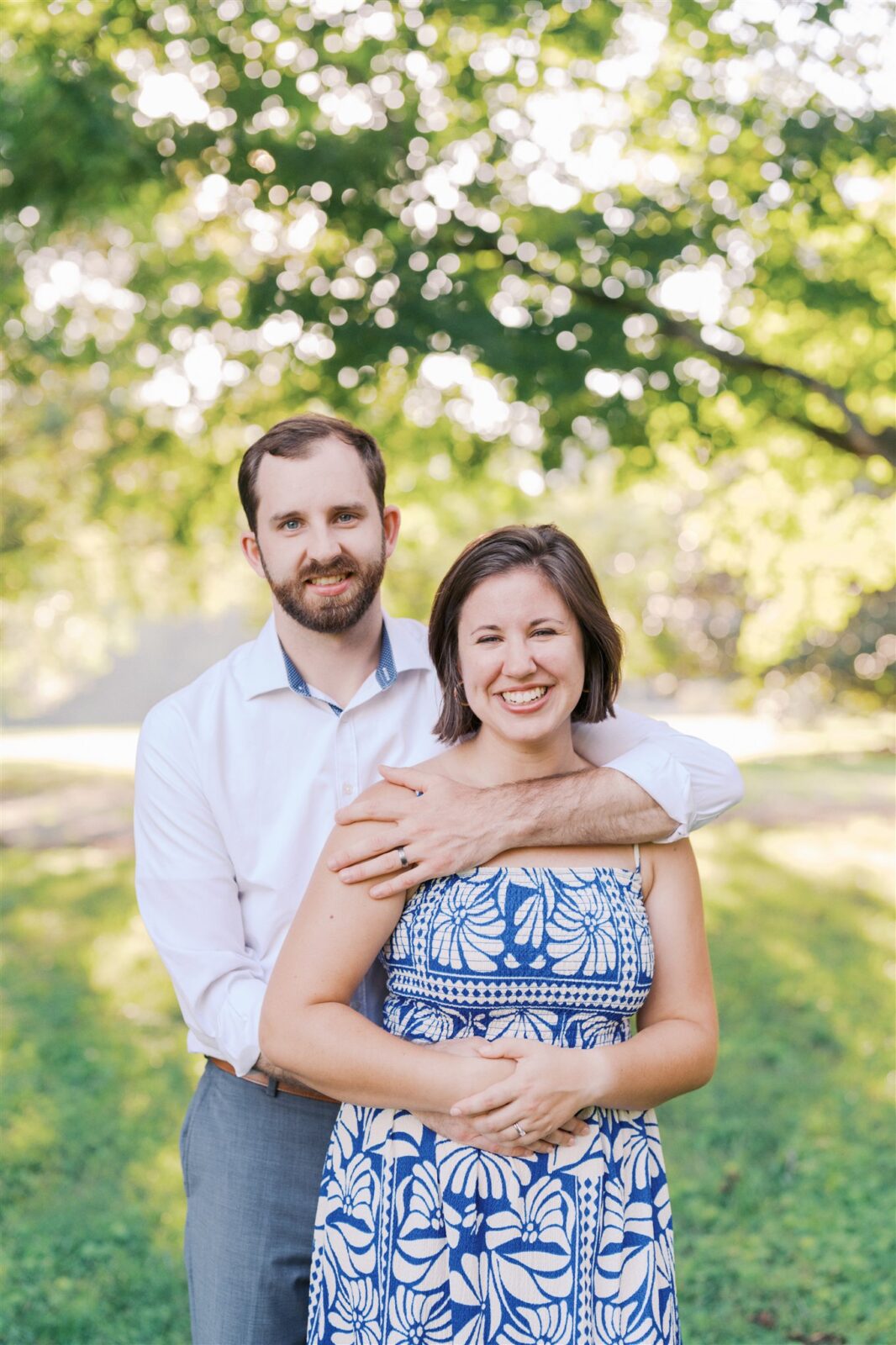 Katie and Sam looking at the camera in beautiful blue and white outfits during their anniversary photo session at Ayr Mount in Hillsborough NC.