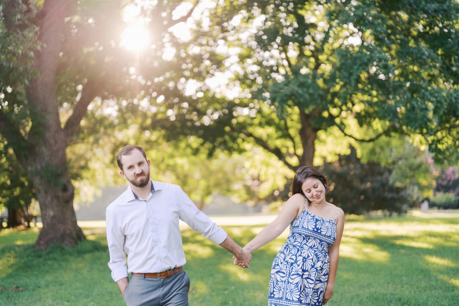 Katie and Sam walking hand in hand at Ayr Mount in Hillsborough NC, showing their personalities with cute expressions during their anniversary photo session.