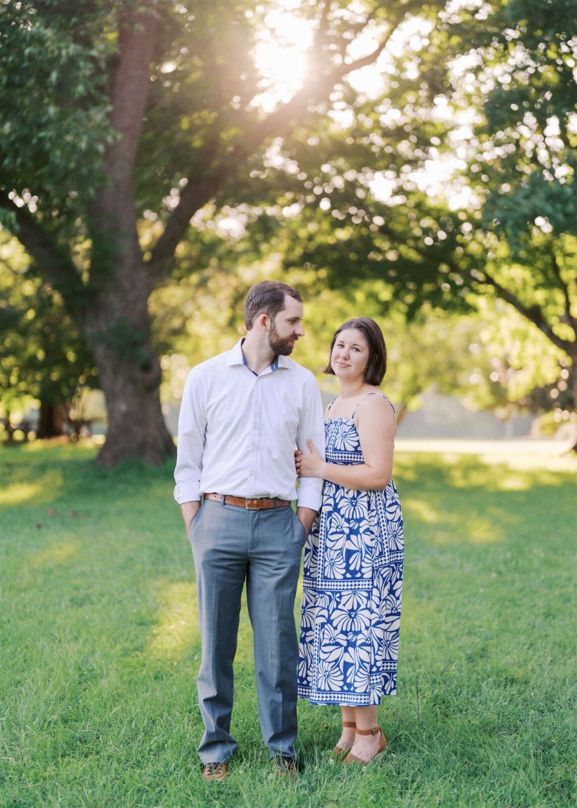 Katie wearing a beautiful blue and white dress during a film-style editorial anniversary photo at Ayr Mount in Hillsborough NC, captured in golden light.