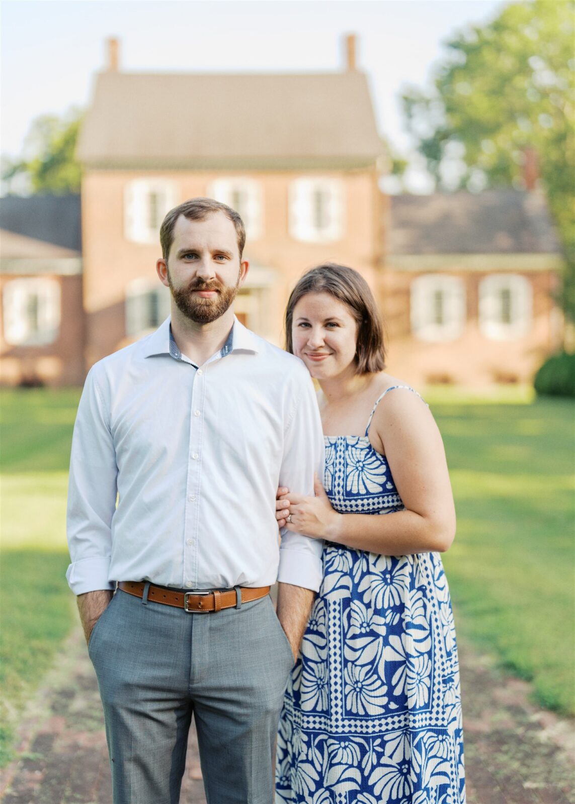 Katie and Sam looking at the camera during their anniversary photo session at Ayr Mount in Hillsborough NC, capturing their joyful connection.