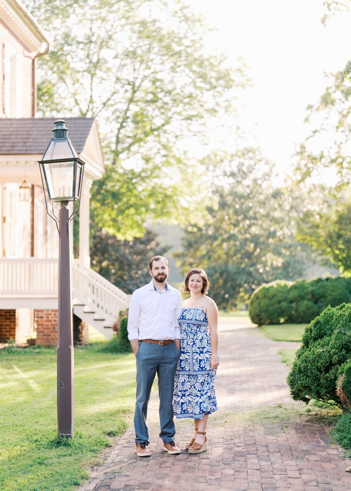Katie and Sam on a historic walkway at Ayr Mount in Hillsborough NC, surrounded by beautiful light during their anniversary photo session.