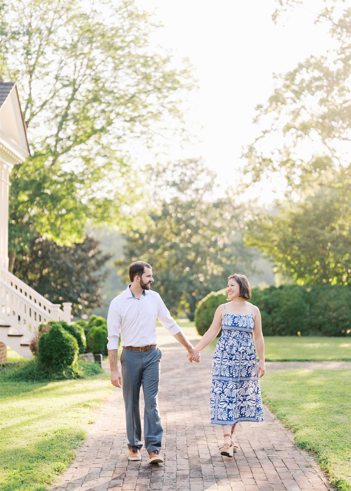 Katie and Sam walking hand in hand through the scenic grounds at Ayr Mount in Hillsborough NC during their anniversary photo session.
