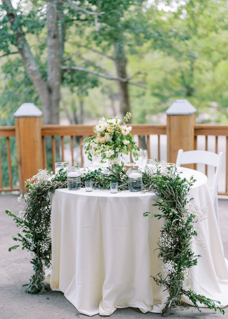 Floral sweetheart table design at The River Lodge at River Landing with soft spring arrangements