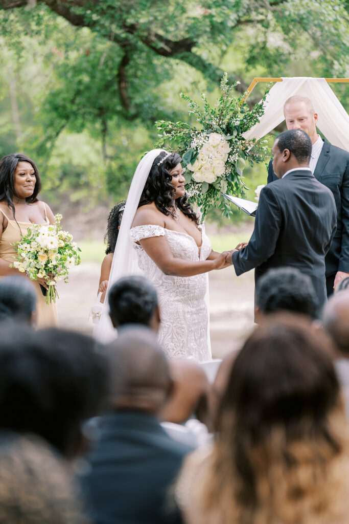 Bride and groom exchanging vows during a Christ-centered wedding at River Landing