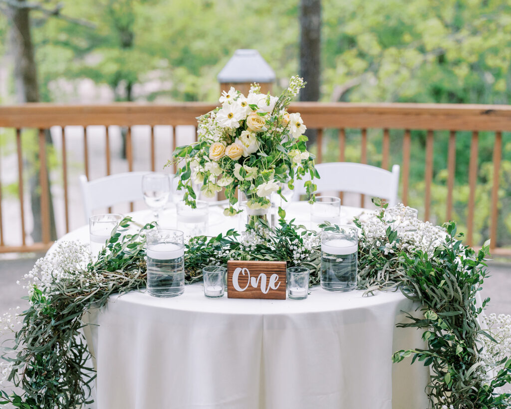 Spring wedding florals arranged along the sandy ceremony space at River Landing in North Carolina