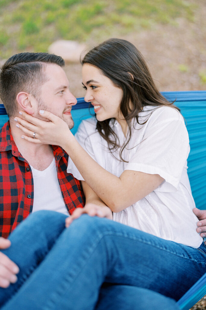 Close-up of Rachel and Nate snuggled together in a hammock during their engagement session at Romare Bearden Park in Charlotte, North Carolina