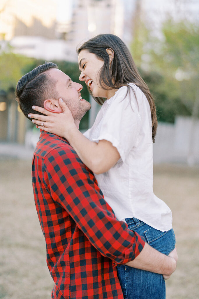 Couple laughing together during their spring engagement session at Romare Bearden Park in Charlotte, North Carolina