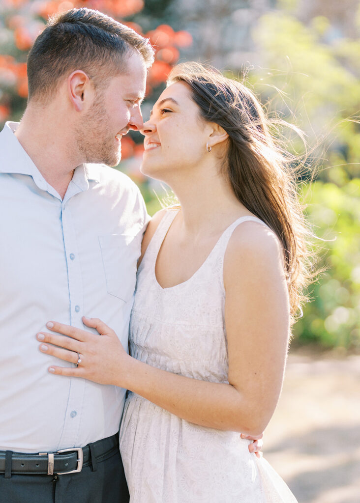 Couple sharing a playful kiss on a sunny spring afternoon in uptown Charlotte
