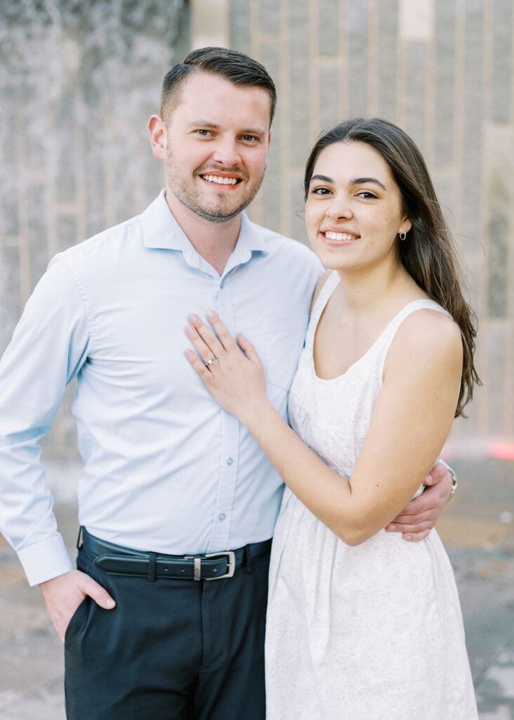 Formal engagement portrait of a couple standing in front of a waterfall at Romare Bearden Park in Charlotte, North Carolina