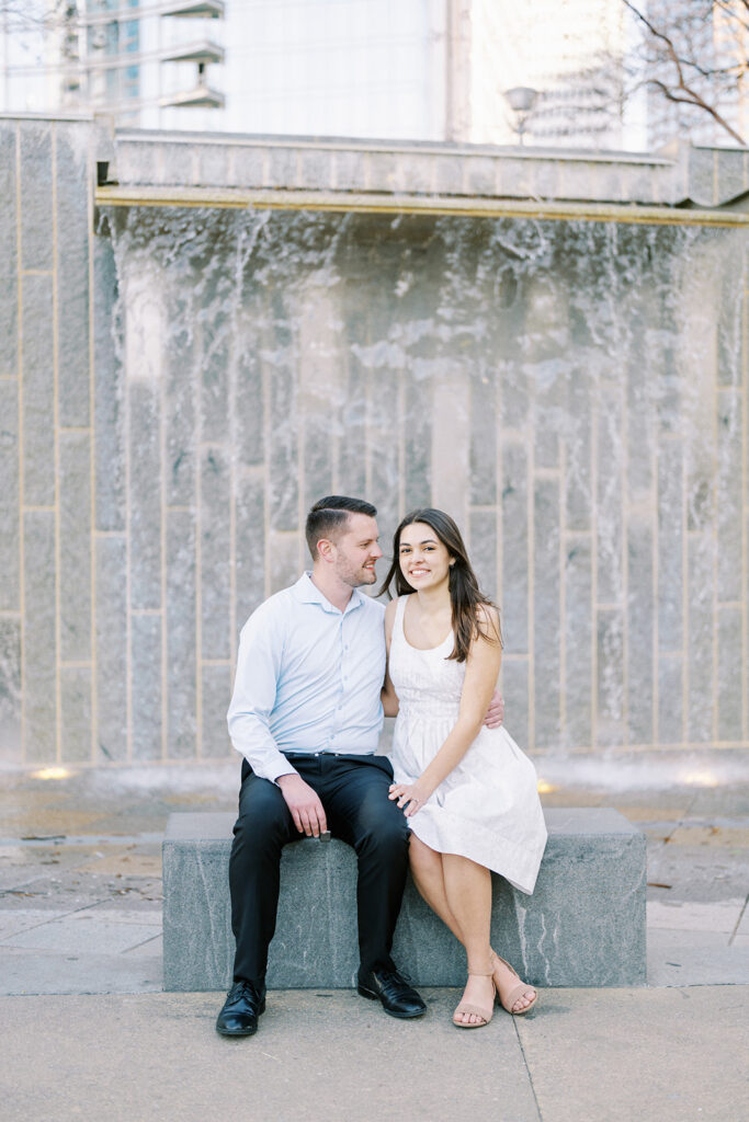 Engaged couple sitting on a park bench enjoying each other’s company at Romare Bearden Park