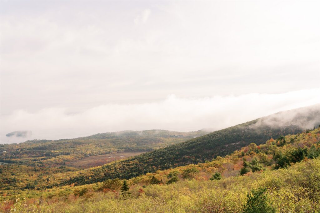 Rolling hills and sweeping terrain of Cadillac Mountain disappearing into the clouds in Acadia Maine
