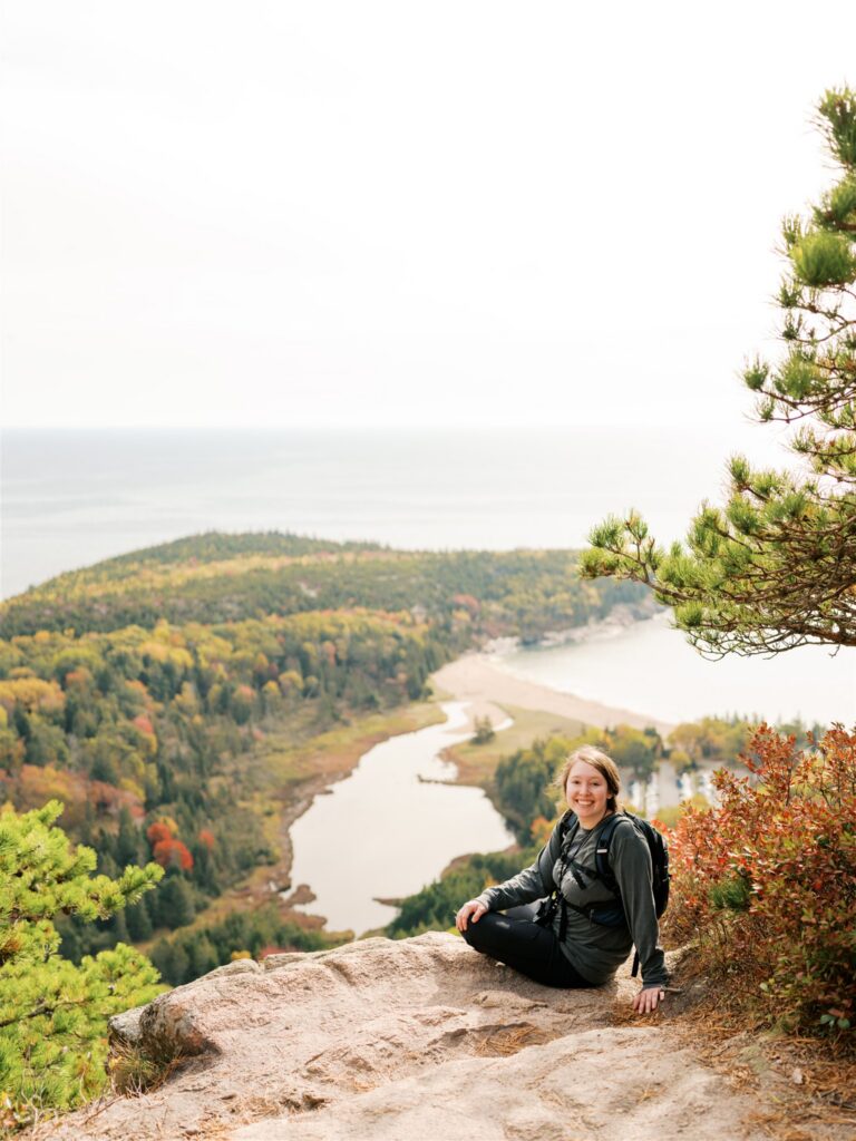 Photographer at the summit of the Beehive Trail in Acadia Maine

