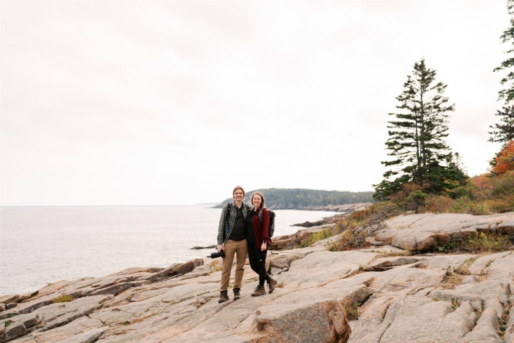 Couple exploring the rocky coastline along the Park Loop Road in Acadia Maine

