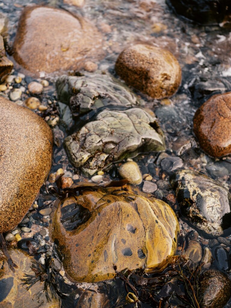 Colorful smooth rounded pebbles on the shore at Little Hunters Beach in Acadia Maine
