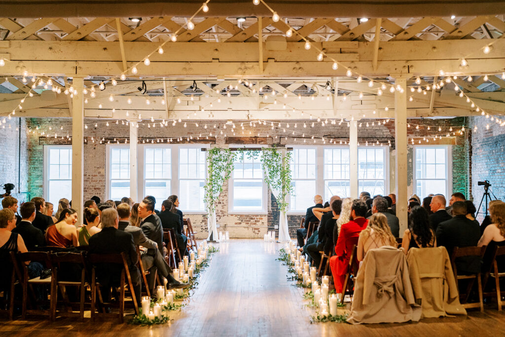 Wedding ceremony taking place inside Stockroom 230 with guests seated and couple at the altar