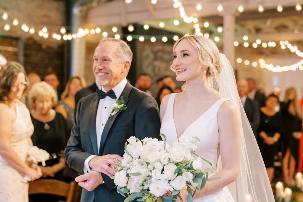 Happy bride walking down the aisle with her father during a wedding ceremony