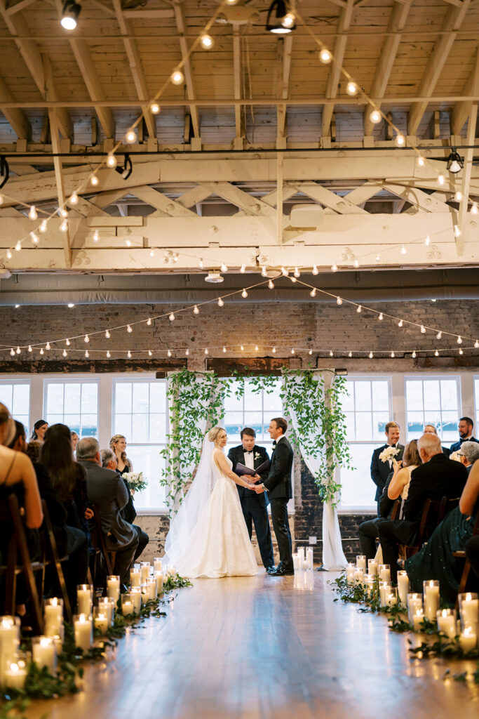 Bride and groom standing together during their wedding ceremony at Stockroom 230