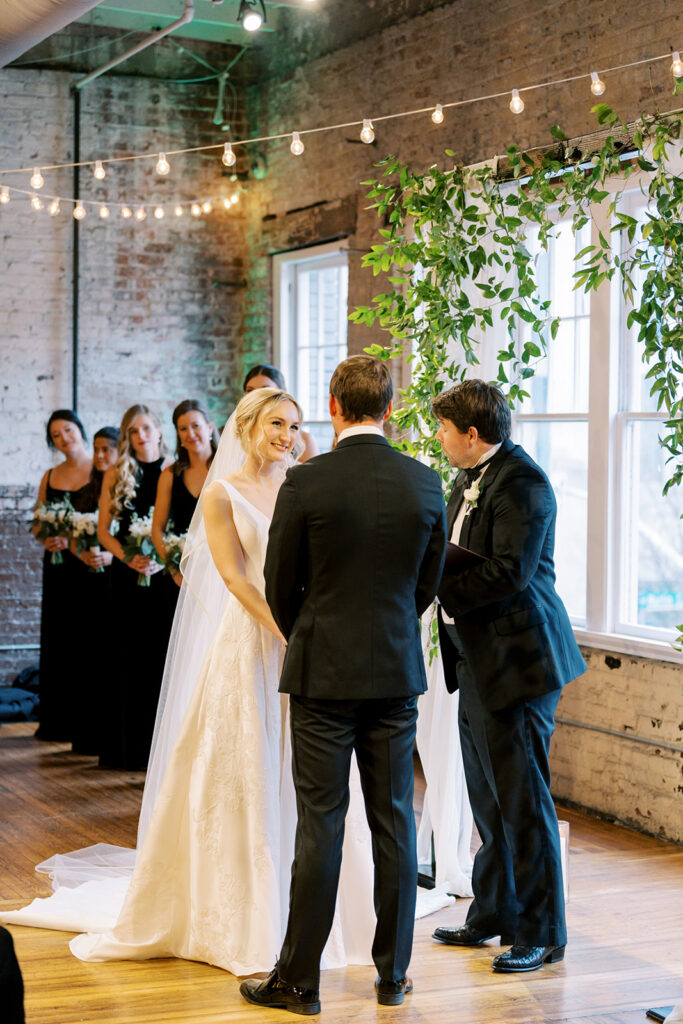Bride and groom exchanging vows during a wedding ceremony at Stockroom 230 in downtown Raleigh