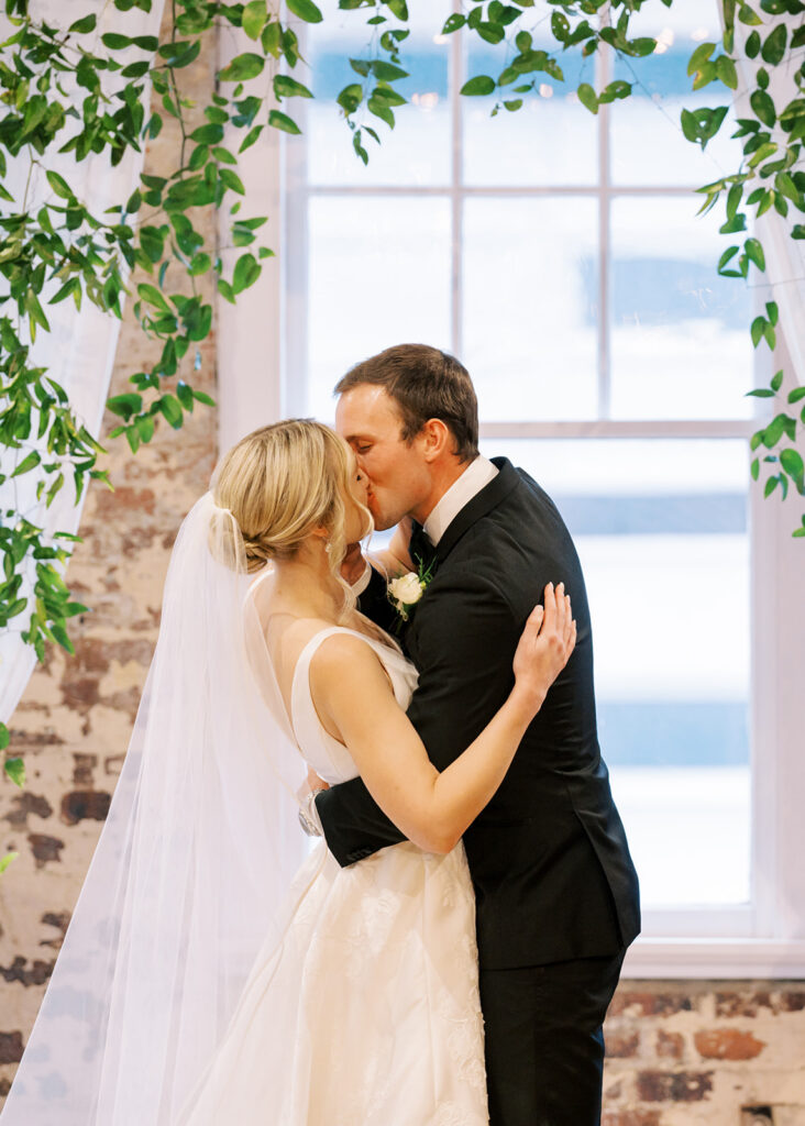 Bride and groom sharing their first kiss as a married couple during the ceremony