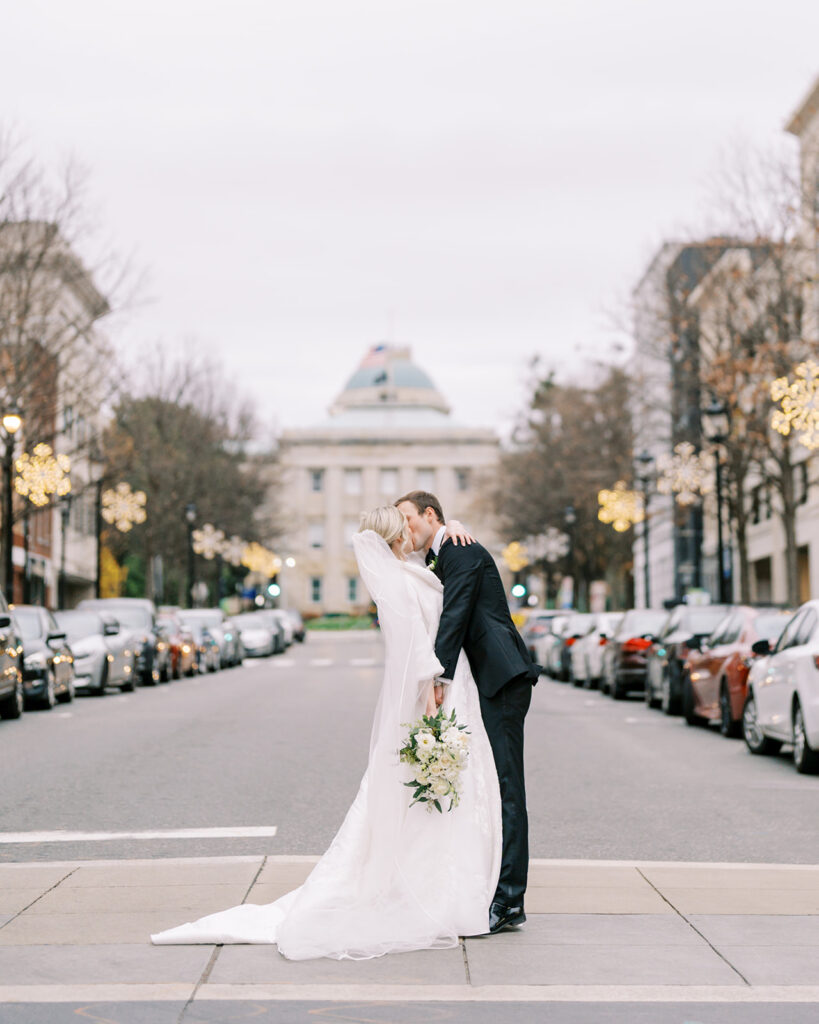 Bride and groom sharing a kiss on the Capitol grounds in downtown Raleigh, NC