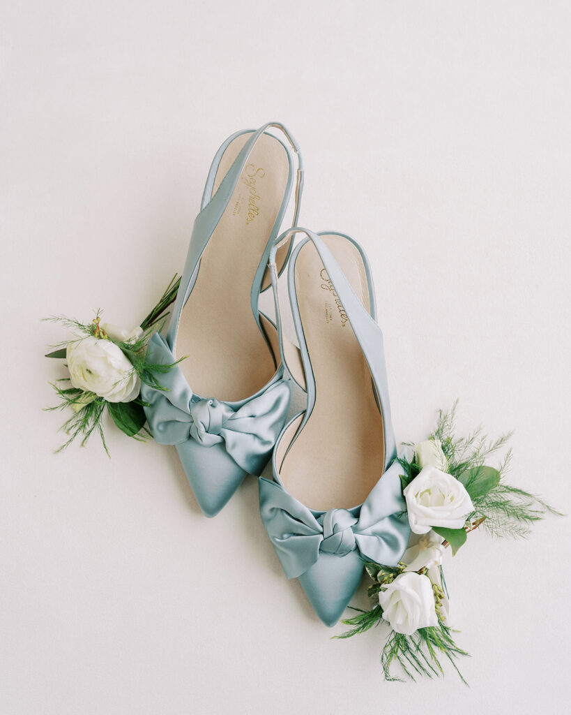Blue Anthropologie bridal shoes surrounded by soft white florals
