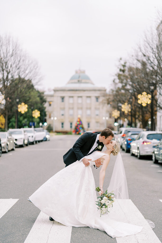 Bride and groom sharing a dip kiss in the middle of a downtown Raleigh street