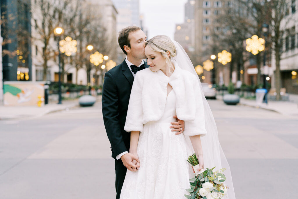 Romantic wedding portrait of bride and groom with Christmas lights in downtown Raleigh
