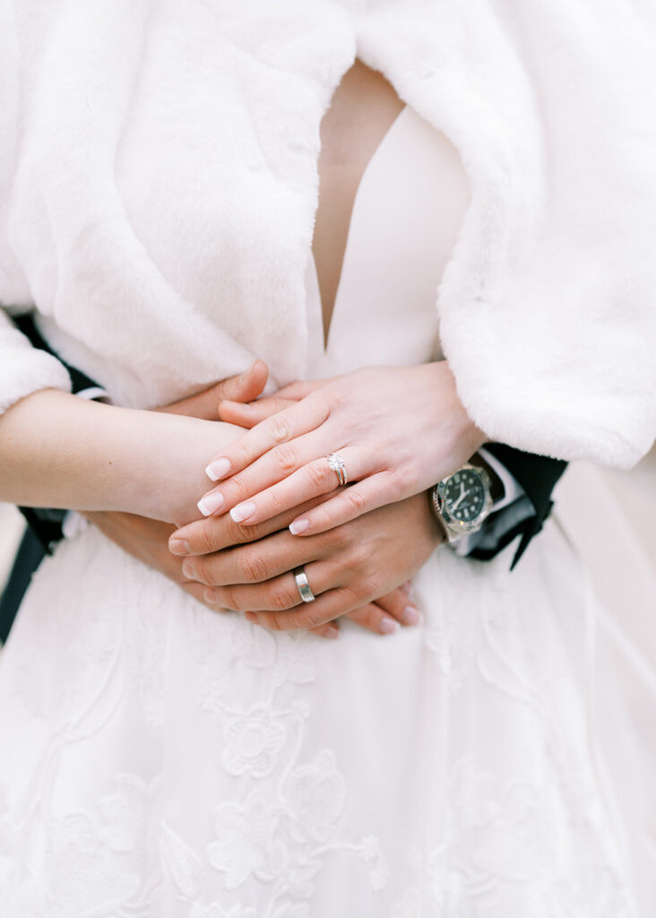 Detail shot of the couple’s hands intertwined on their wedding day
