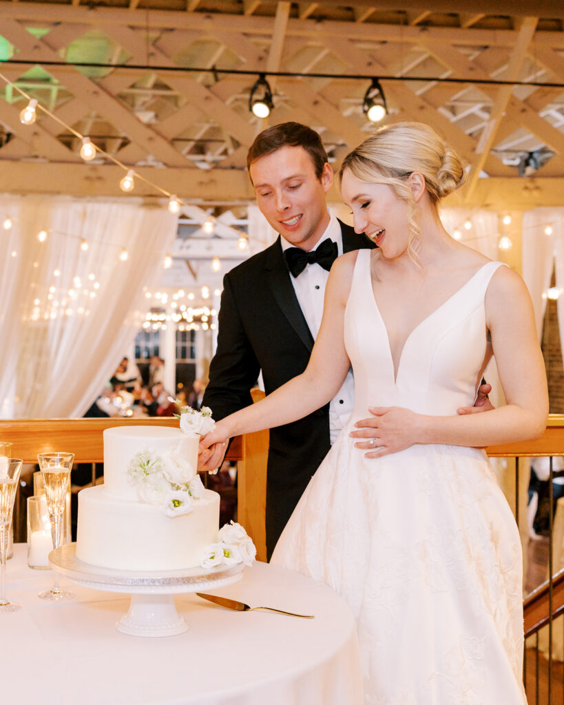 Bride and groom cutting their wedding cake together at the reception