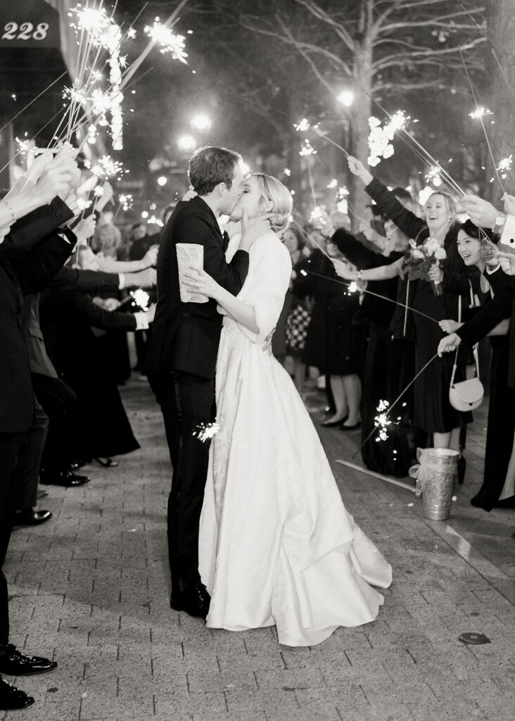 Bride and groom kissing during a sparkler exit at their wedding