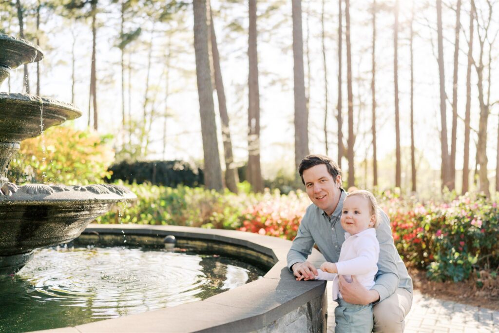 Toddler and dad together at the fountain at WRAL Azalea Gardens