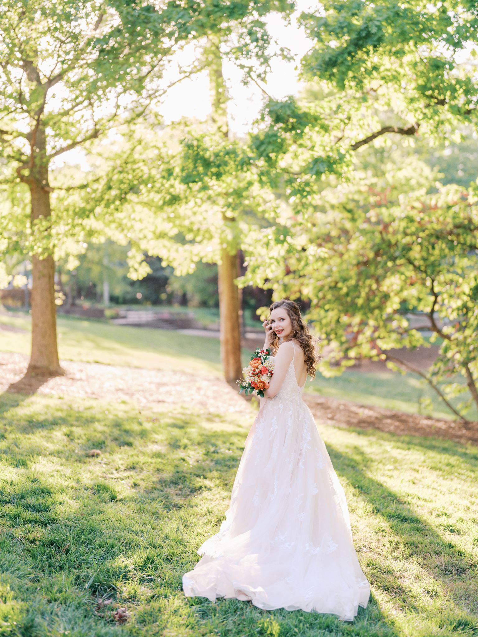 Editorial bridal portrait showing the back of a wedding dress at Glencairn Garden surrounded by greenery