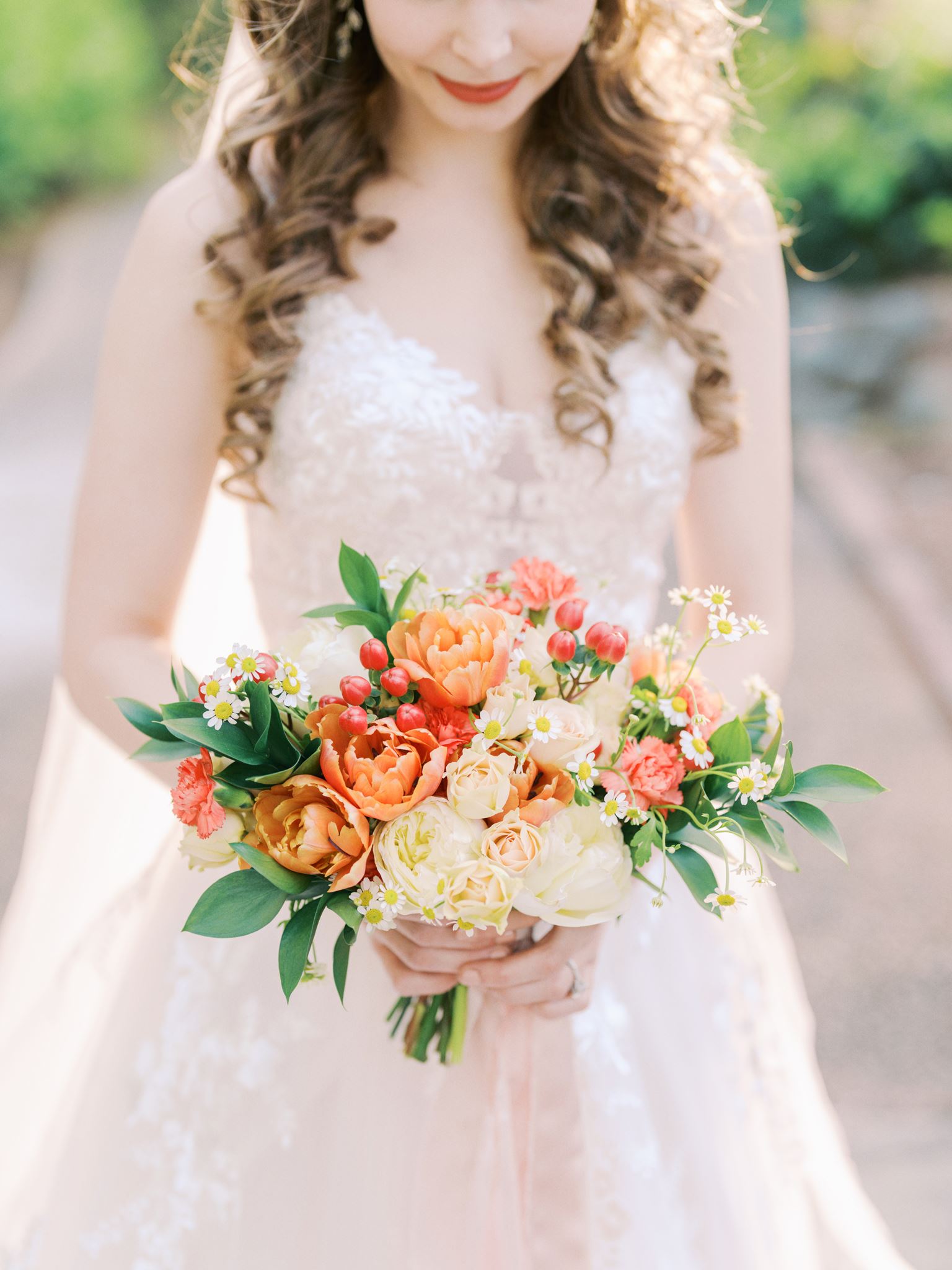Close-up bridal bouquet featuring orange tulips, white roses, and yellow daisies during a Glencairn Garden bridal portrait session