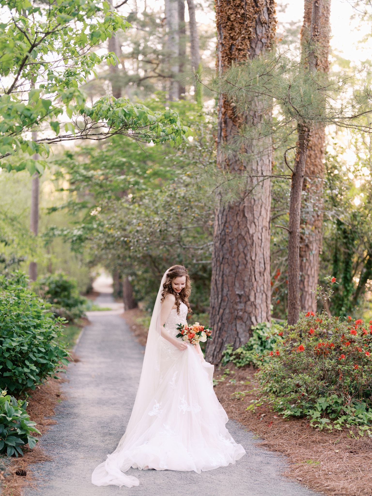 Bridal portrait of a bride standing on a forest garden path during a Glencairn Garden bridal portrait session