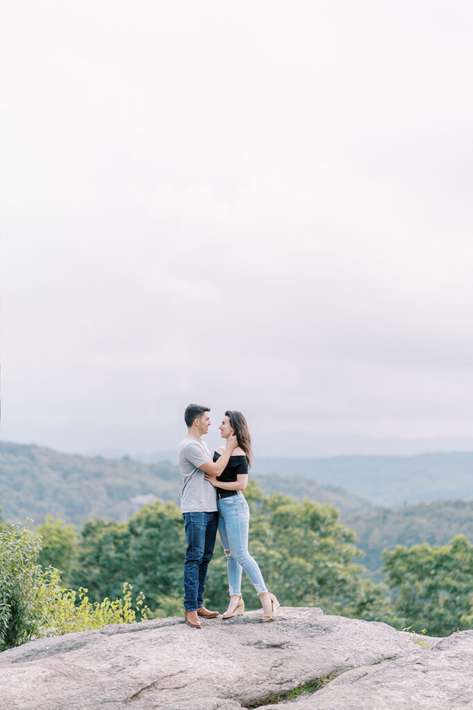 Engaged couple embracing against the mountain backdrop at Raven Rocks on the Blue Ridge Parkway near Boone, NC
