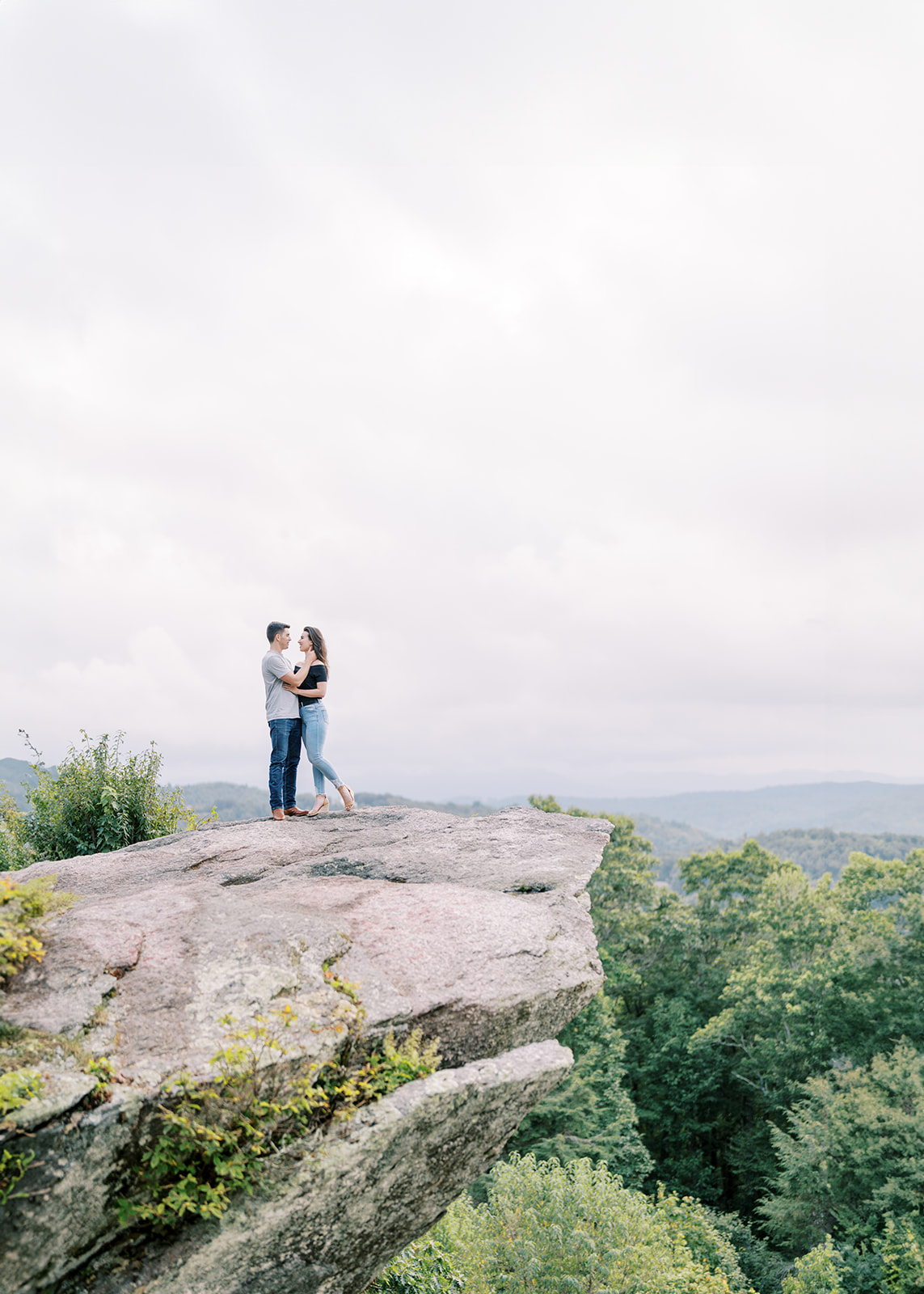 Engaged couple standing together against the mountain views at Raven Rocks on the Blue Ridge Parkway near Boone, NC